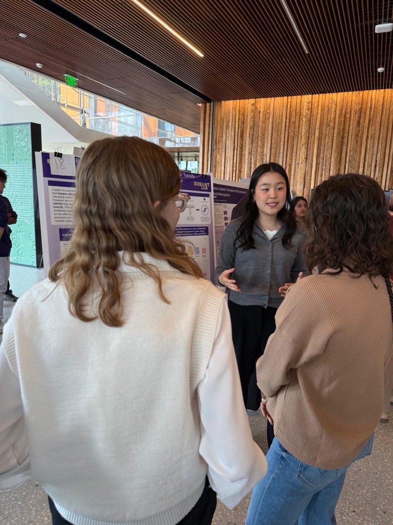 Katherine presenting her poster to a group of people.